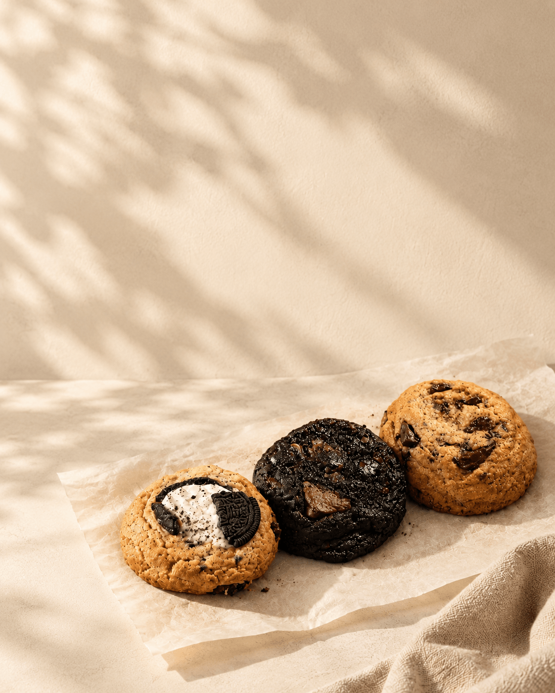 Tres cookies de Angelada recién horneadas sobre papel manteca, con luz natural